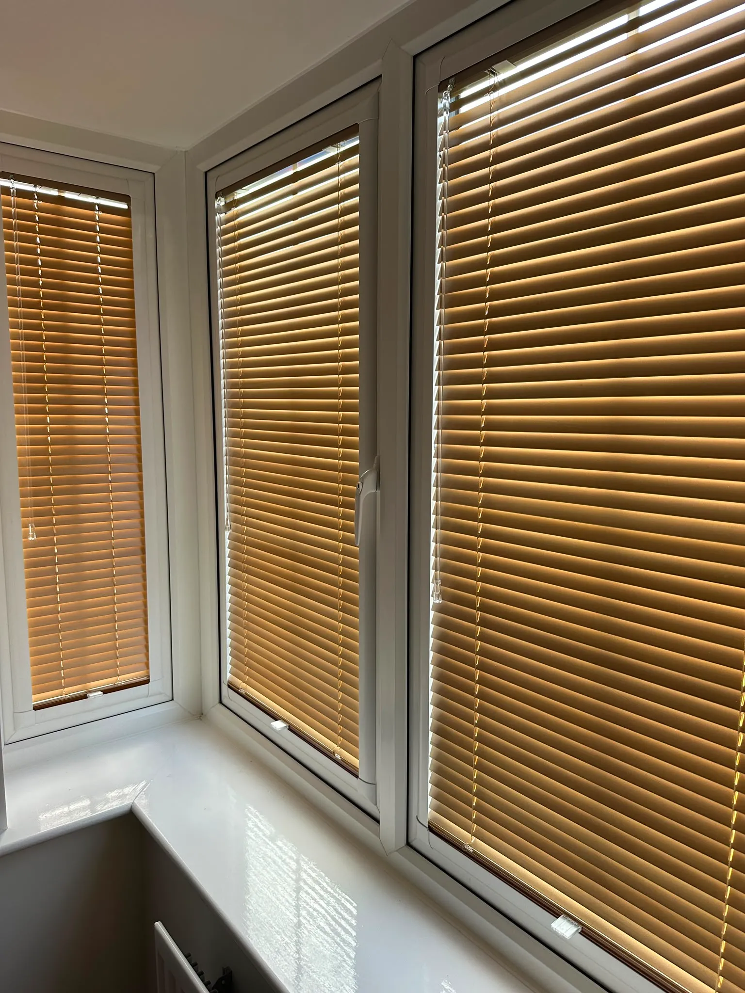 Oak wood-effect Perfect Fit Venetian blinds on a kitchen bay window
