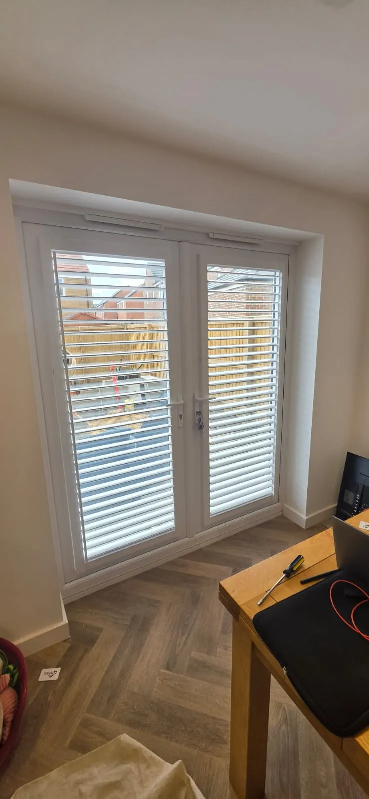 White Perfect Fit plantation shutters with louvres tilted open on French doors