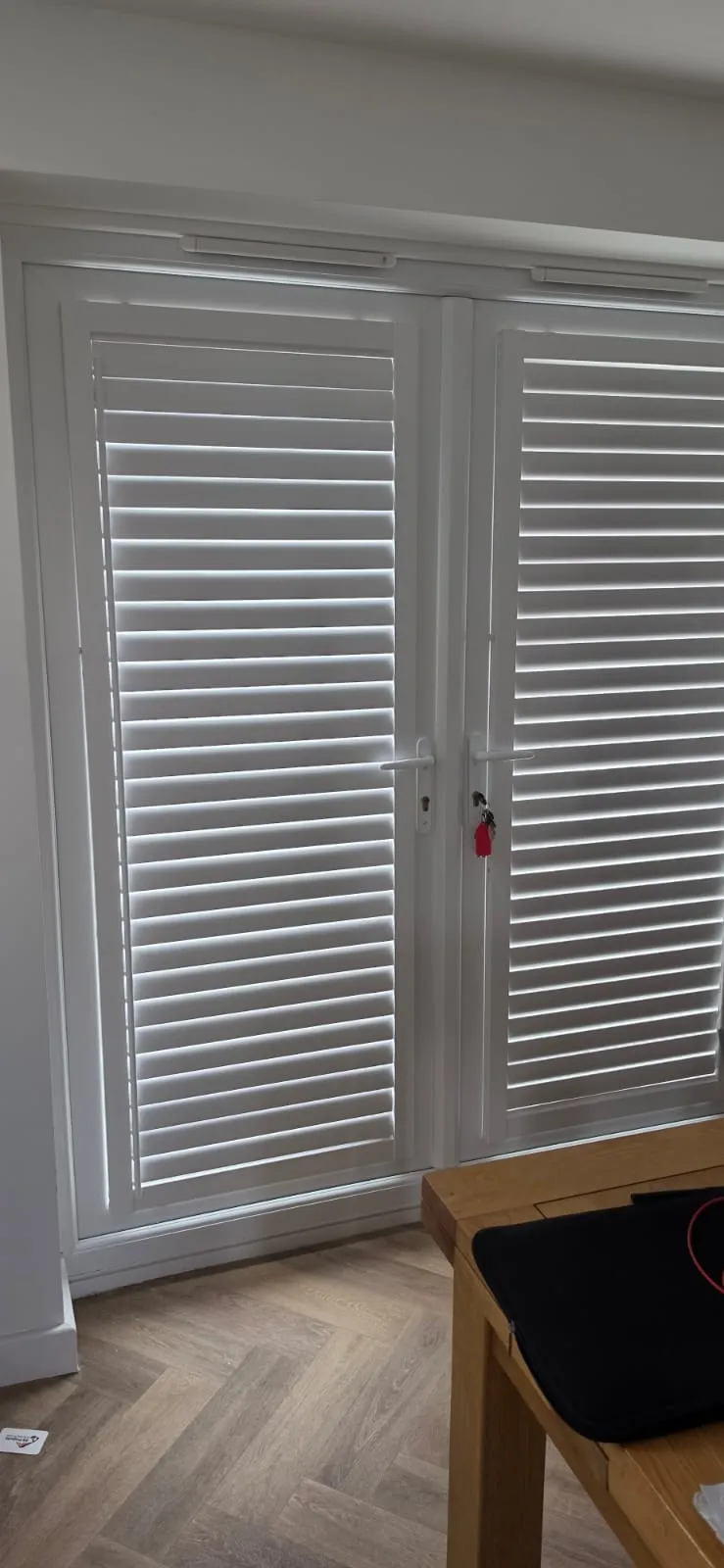 White full-height Perfect Fit plantation shutters closed across French doors