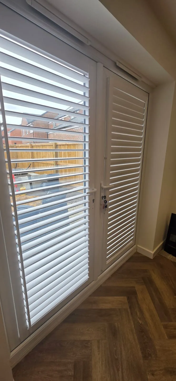 White Perfect Fit plantation shutters on a patio door and full-length window