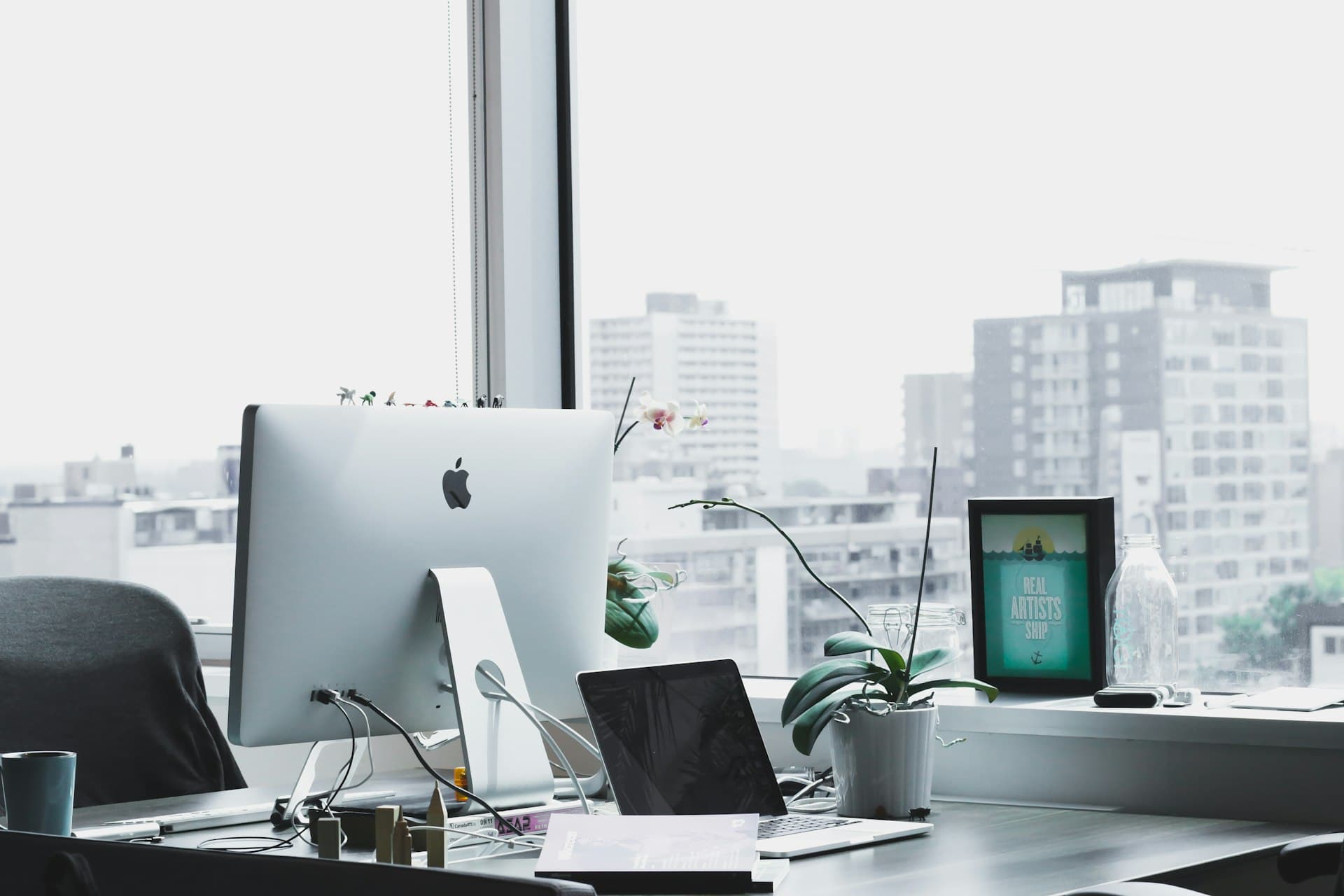 Office desk with computer monitor positioned beside a large window