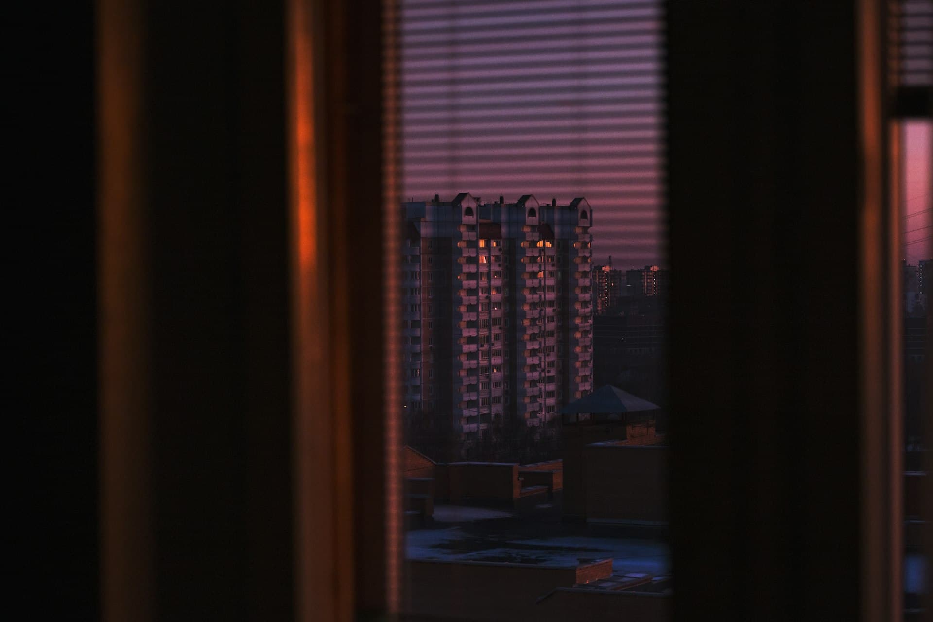 Dark tier-on-tier shutters fitted to an interior window with an ocean view