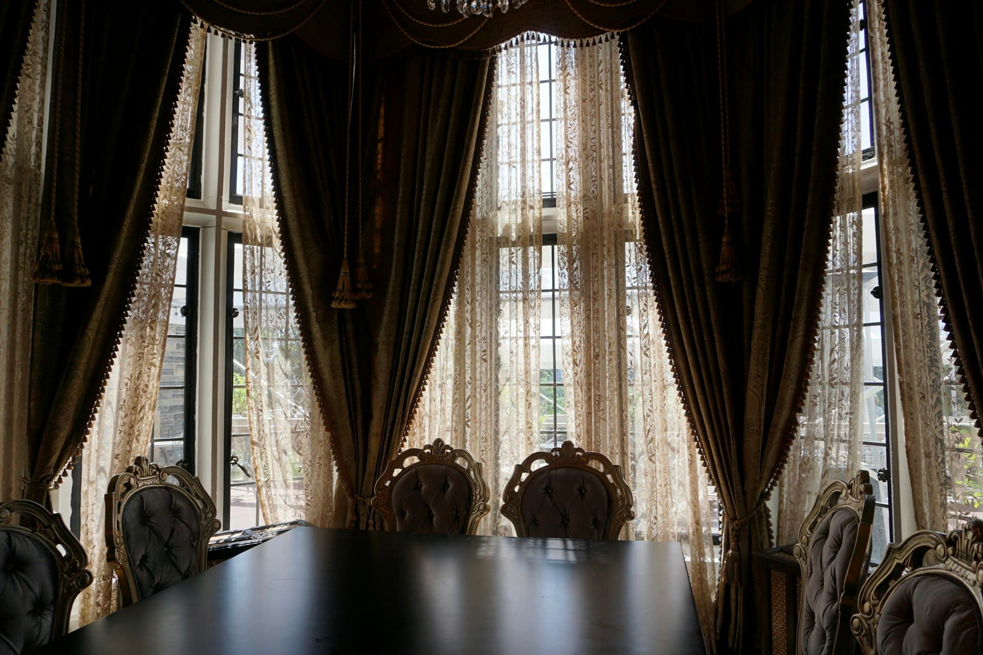 Elegant dining room window dressed with layered curtains
