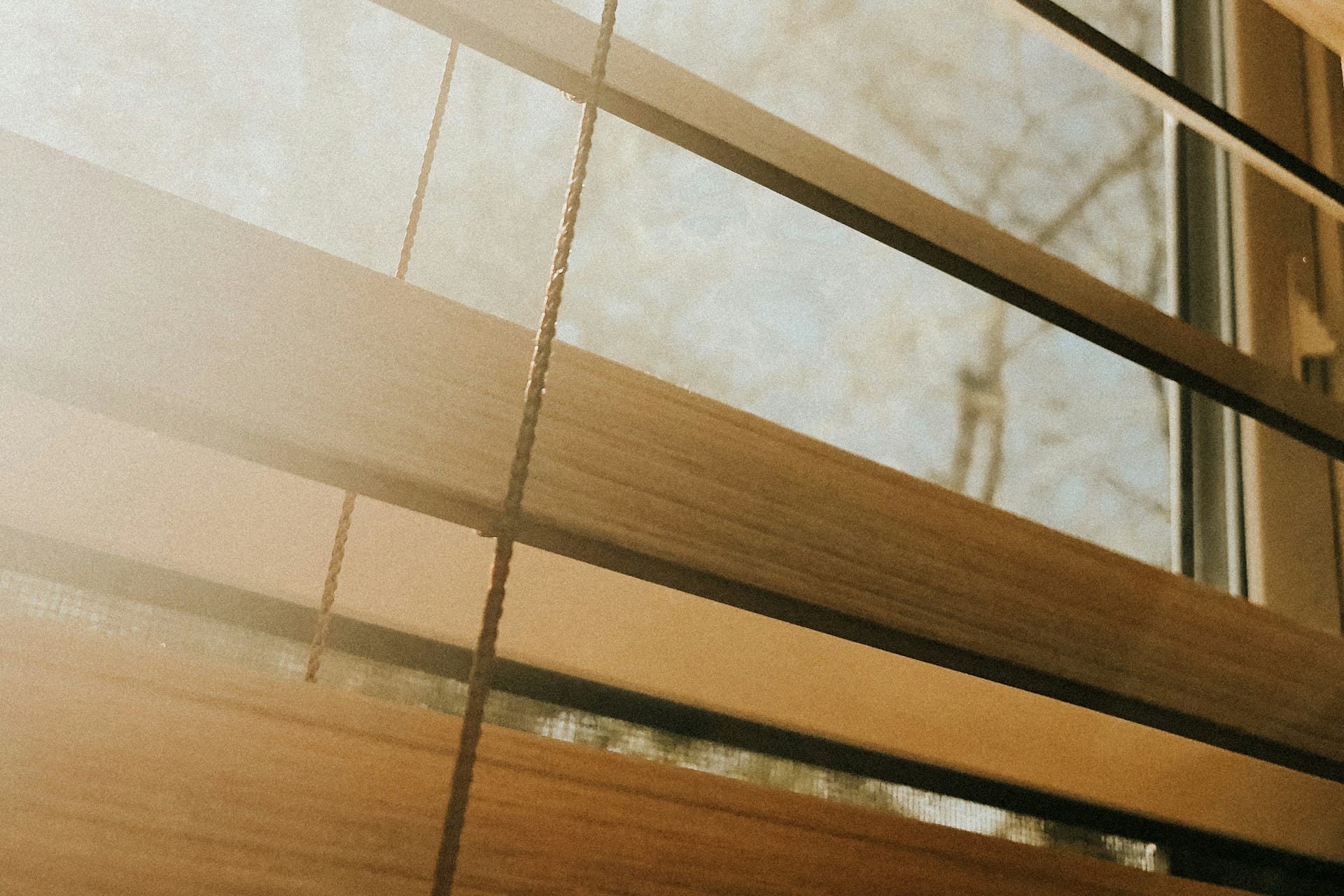 Close-up of a wooden Venetian blind fitted to a sunlit window
