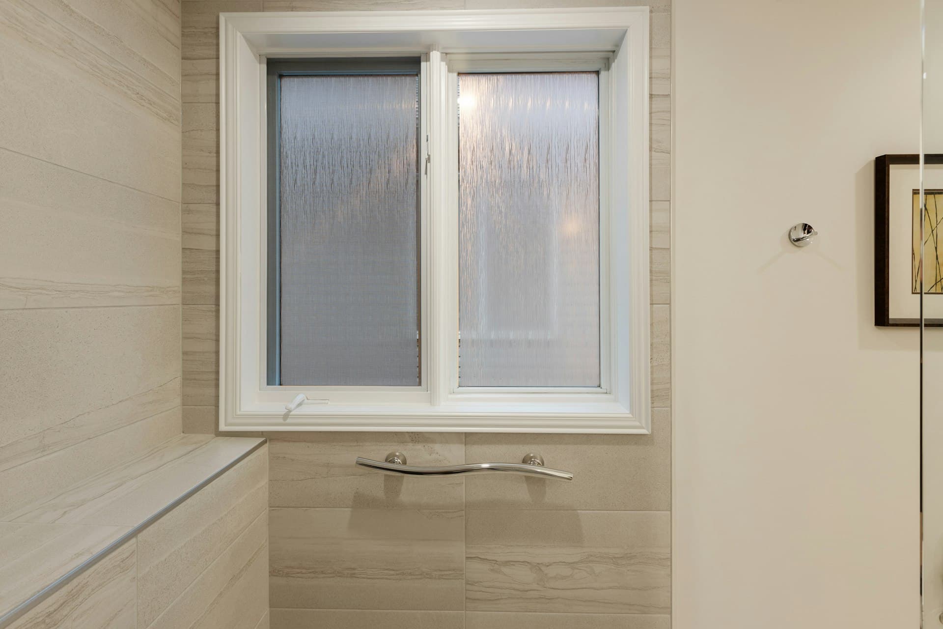 Frosted bathroom window with a chrome towel rail beneath it