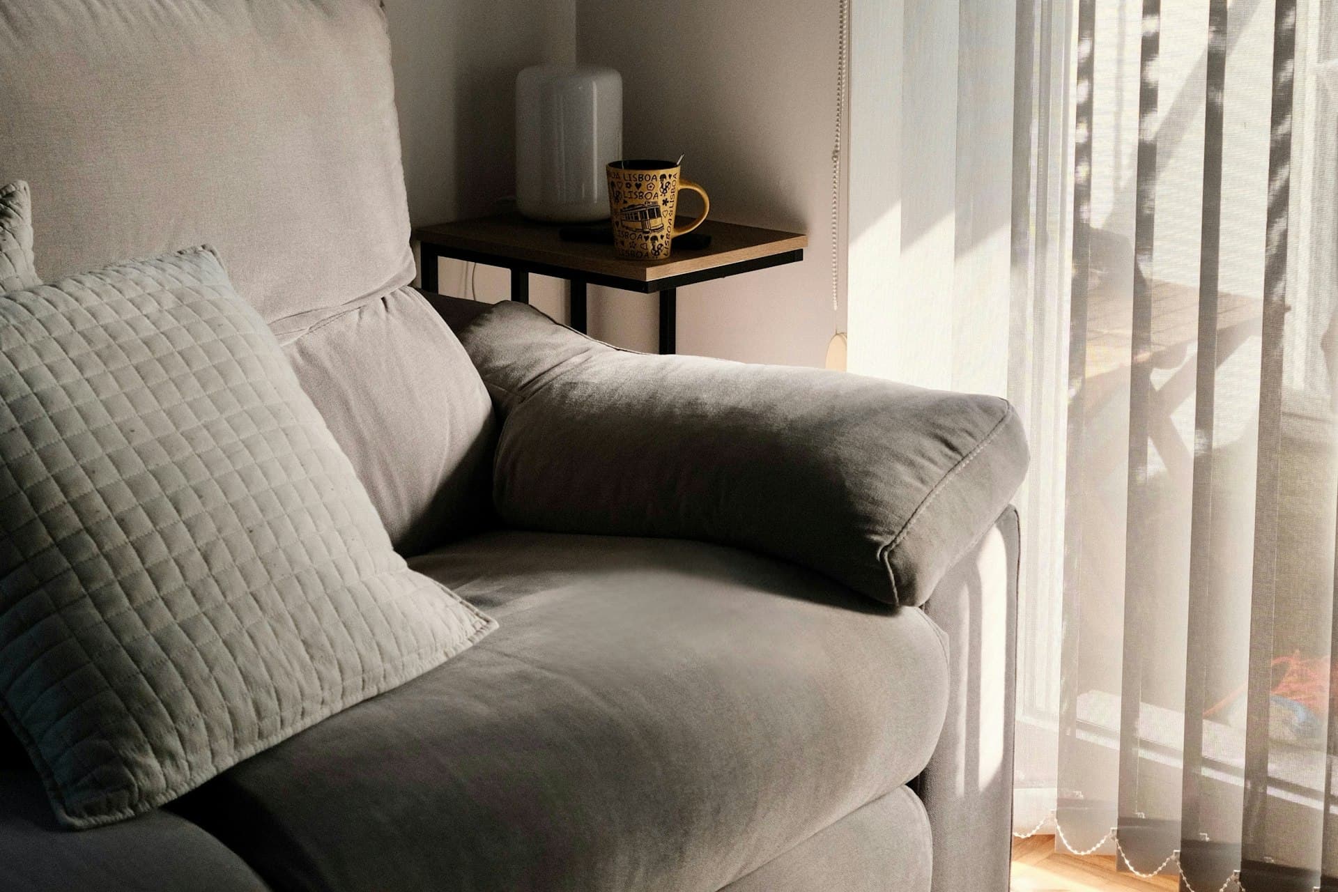 Living room armchair beside a window dressed with sheer curtains